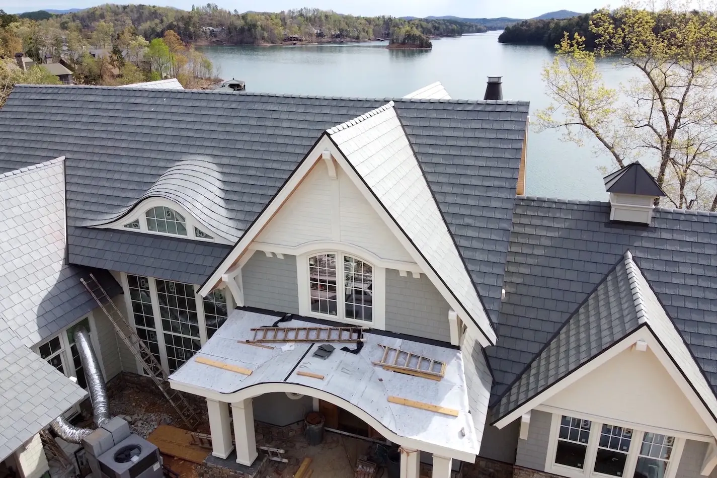 Residential house with slate roofing and custom metal chimney caps.